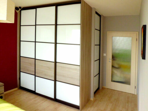 Vestavěná skříň do ložnice s posuvnými dveřmi s výplní bílé lakované sklo.