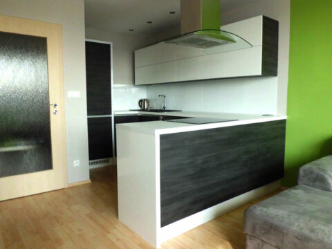 Kuchyň na míru do "U" v kombinaci bílého lesku a tmavého dřevodekoru.