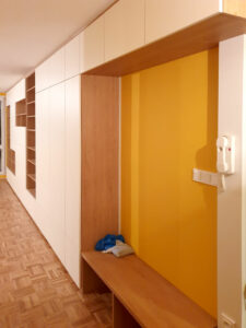 Realizace pantové skříně na míru v bílé barvě kombinované s dřevěnými prvky.