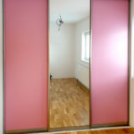 Skříň na míru s posuvnými dveřmi v růžové barvě se zrcadlem.