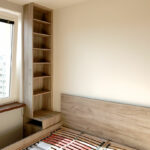 Otevřená policová skříň do ložnice v dekoru světlého dubu.