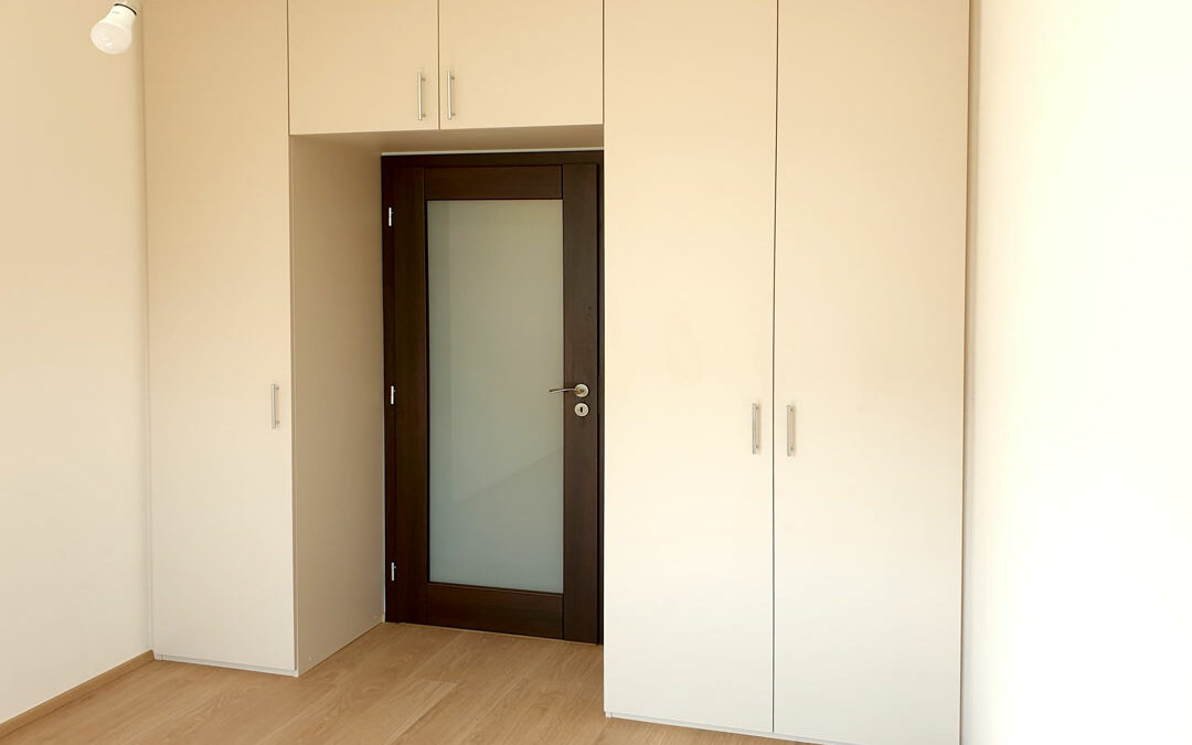 Realizace skříně do ložnice s pantovými dveřmi v bílé barvě.