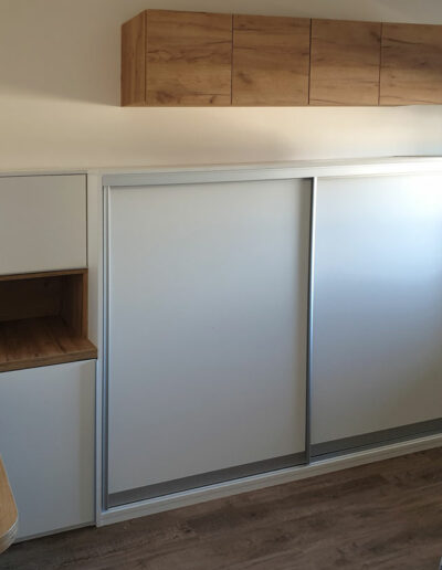 Nízká do ložnice s posuvnými i pantovými dveřmi a pracovním stolem.