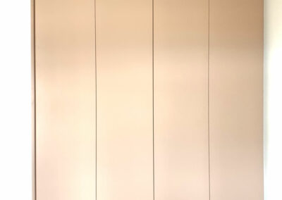 Pantová vestavěná skříň s bezúchytkovým otevíráním v krémové barvě.