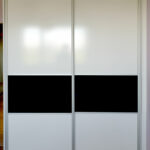 Vestavěná skříň s posuvnými dveřmi v bílé barvě s dělením černým pruhem.