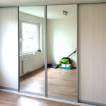Realizace skříně na míru do ložnice s posuvnými dveřmi. Kombinace světlého dřeva a zrcadel.