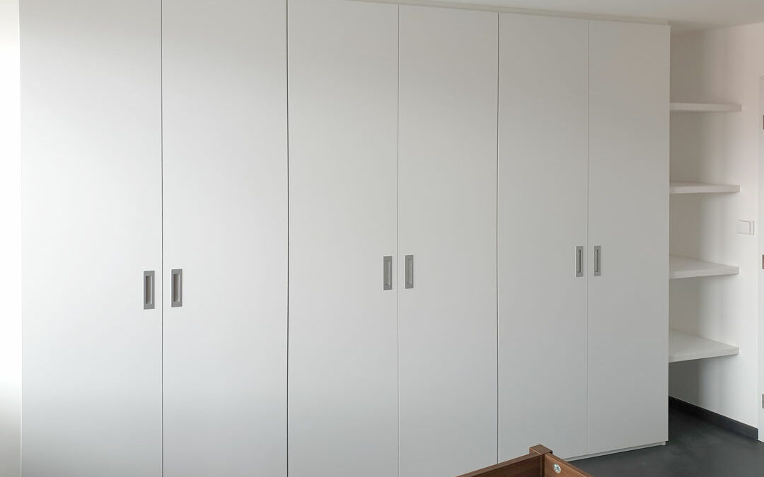 vestavene-skrine-realizace-091 Realizace skříně na míru do ložnice s pantovými dveřmi v bílé barvě a zafrezovanými úchytkami.