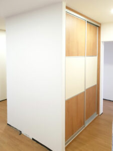 Realizace vestavěné skříně s posuvnými dveřmi s horizontálním dělením.