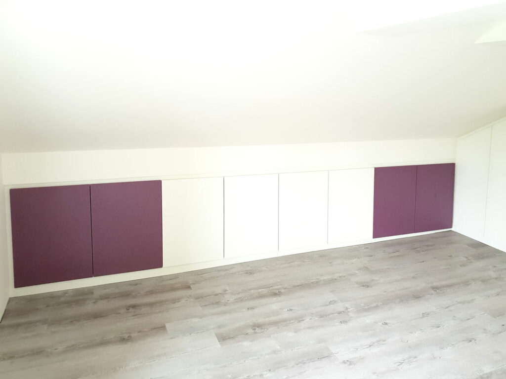 Nízká vestavěné skříň do podkroví s pantovými dveřmi.