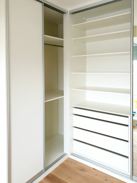 vestavene-skrine-realizace-127 Interier rohové skříně na míru s posuvnými dveřmi v bílé barvě.