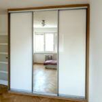 Realizace vestavěné skříně s posuvnými dveřmi v kombinaci zrcadla a lakovaného skla / lacobelu