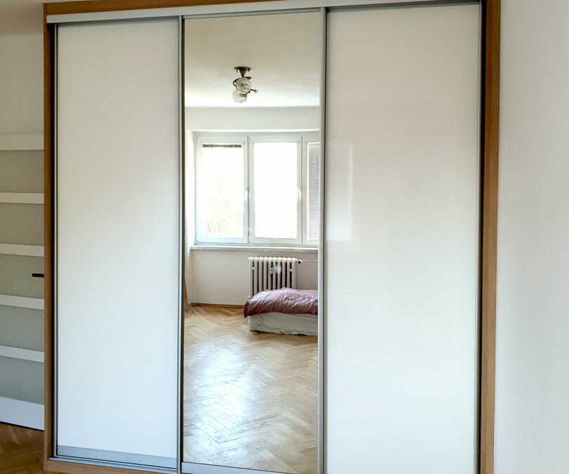 Realizace vestavěné skříně s posuvnými dveřmi v kombinaci zrcadla a lakovaného skla / lacobelu