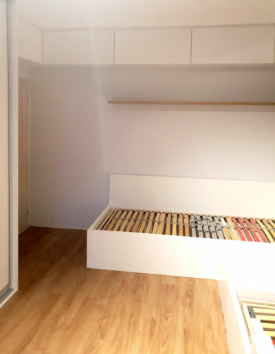 Realizace dětského pokoje se dvěmi postelemi, vetsavěnou skříní a pracovním stolem.