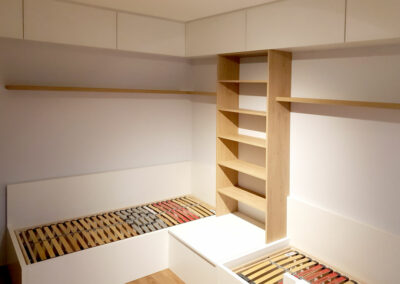 Realizace dětského pokoje se dvěmi postelemi a skříněmi.