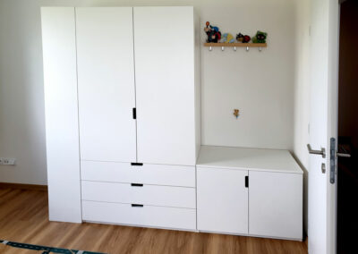 Skříň na míru do chodby s pantovými dveřmi a prostorem na věšáky.