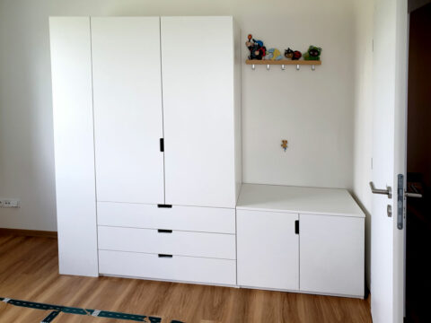 Skříň na míru do chodby s pantovými dveřmi a prostorem na věšáky.