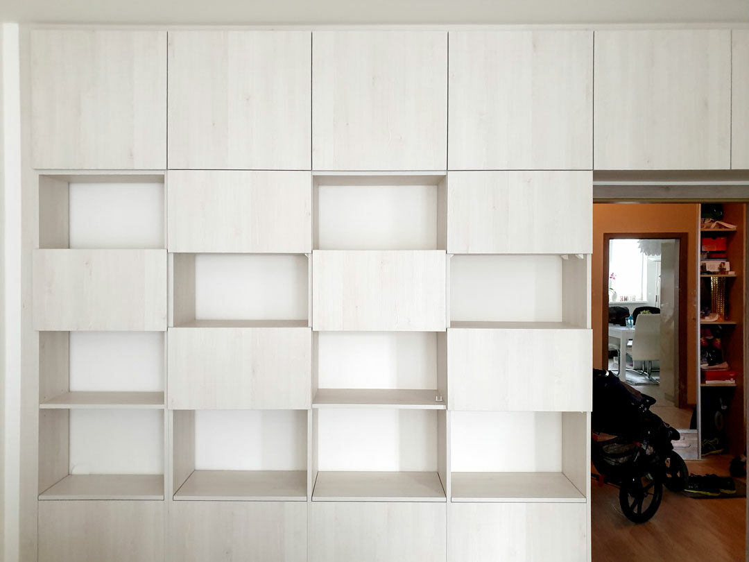 vestavene-skrine-realizace-144 Vestavěná skříň do obýváku s částečně otevřenými policemi ve stavělém dekoru.