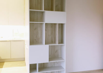 vestavene-skrine-realizace-153 Otevřená knihova v dekoru přírodní dub a krémová barva.