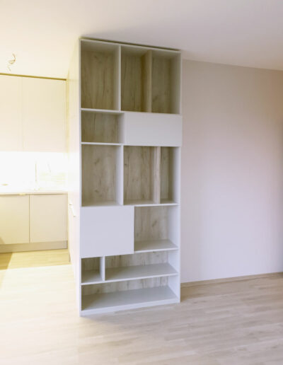 vestavene-skrine-realizace-153 Otevřená knihova v dekoru přírodní dub a krémová barva.