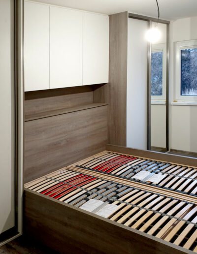 vestavene-skrine-realizace-154 Ložnice na míru s postelí a vestavěými skříněmi v dekoru přírodní dub a krémová barva.