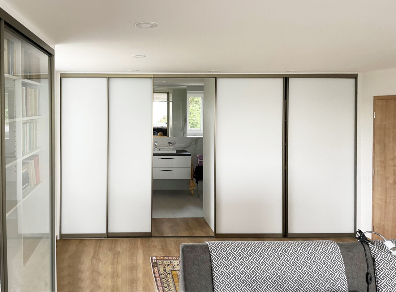 Vestavěná skříň s posuvnými dveřmi a vstupem do koupelny, součástí návrhu kompletního interiéru