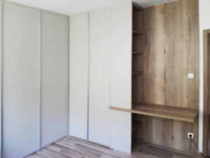 Bílá pantová skříň s pracovním stolem a otevřenými policemi v dřevodekoru